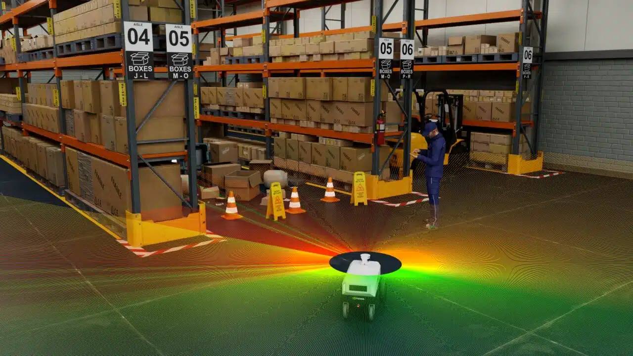 A person in a warehouse with a robot
Description automatically generated